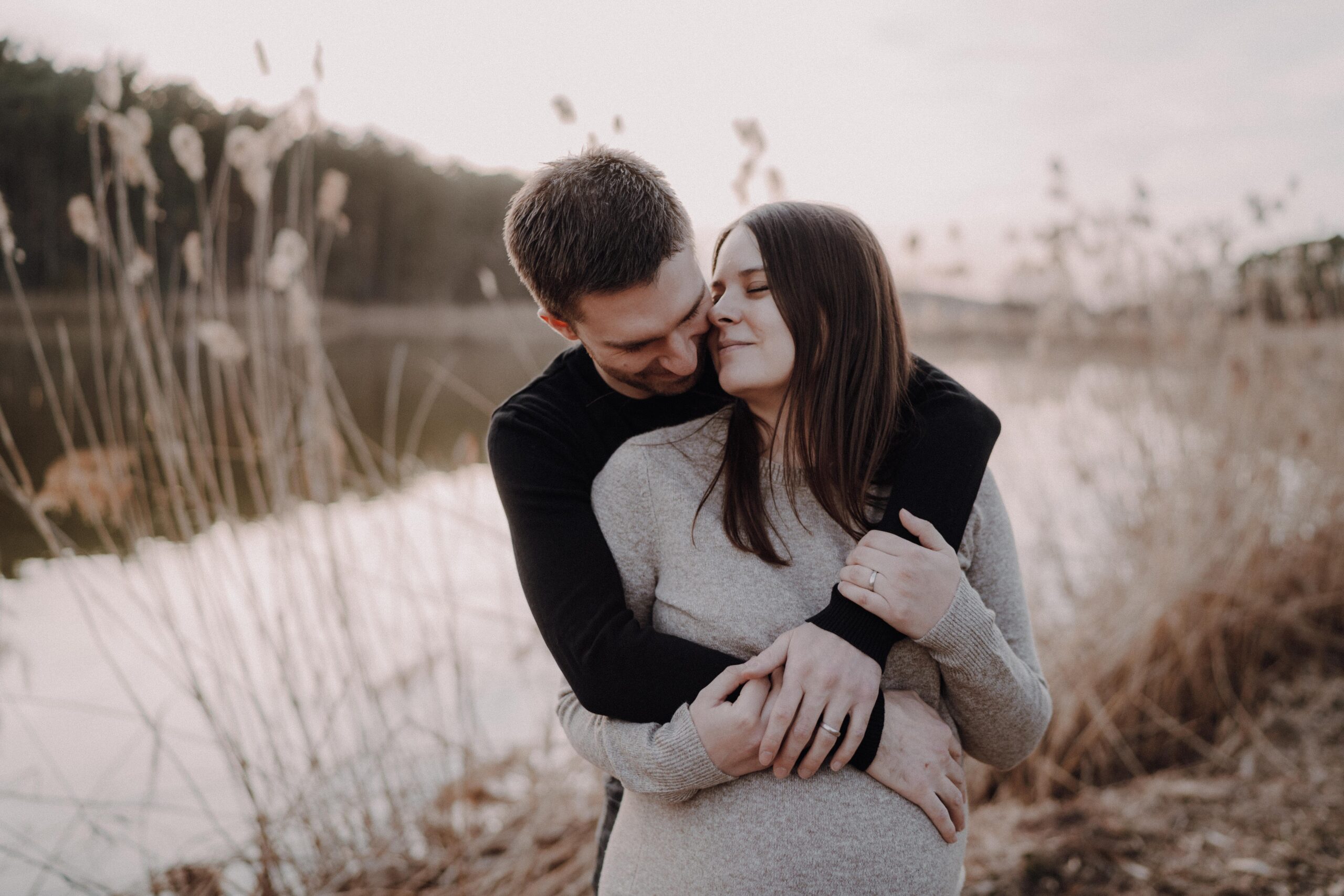 20250321-MVA00200_Babybauch_Babybelly_Babyinside_Vorfreude_Familienzuwachs_Maternity_Schwangerschaftsfotos_Paarfotos mit Babybauch_Babybauchmomente_See_Schilf_Sonnenuntergang_Sunset